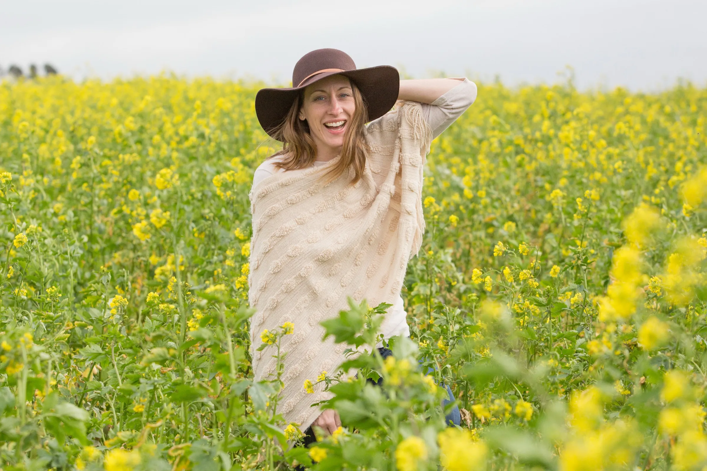 Annie Smith laughing outdoors in a wide-brimmed hat